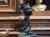une statue représentant une femme tenant un panier posé sur une table