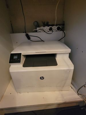 une imprimante blanche posée sur un meuble blanc