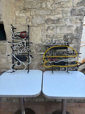 two tables that are sitting next to each other in front of a stone wall