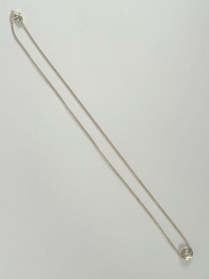 a white gold necklace with a single diamond on a chain