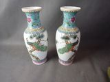 deux vases ornés d'oiseaux, posés sur une table