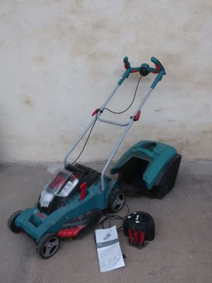 a lawn mower that is sitting on the ground next to a wall