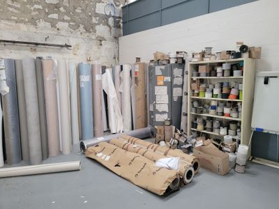 many rolls of fabric on the floor in a room