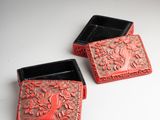 two red and black boxes sitting on top of a white table
