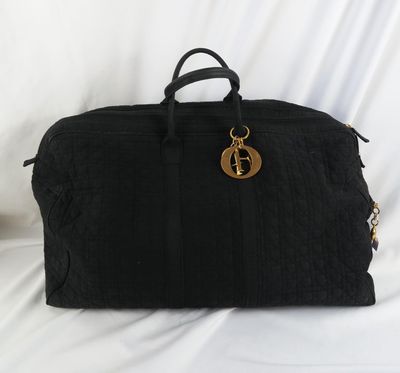 un sac de voyage noir posé sur un drap blanc