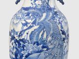 un vase bleu et blanc posé sur une surface blanche