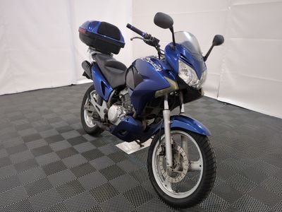 a blue motorcycle parked in a room with a checkered floor