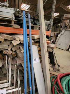 a pile of wood in a warehouse with a blue hose