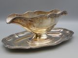 an antique silver plate with a saucer on it on a tray
