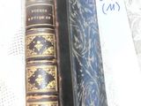 two old books sitting on a table with a note in front of them