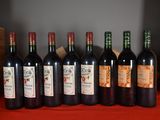 several bottles of red wine are lined up on a table