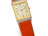 une image représentant une montre-bracelet avec un bracelet orange posée sur une surface blanche