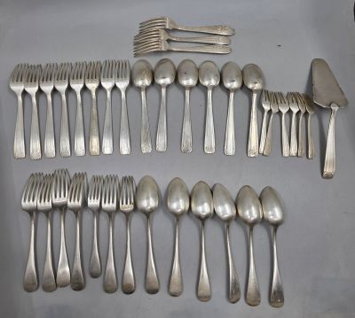un grand nombre de cuillères et de fourchettes en argent disposées sur une table