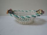 a white basket with flowers in it on a table