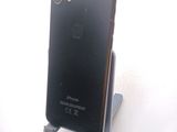 a black iphone sitting on a stand on a white surface