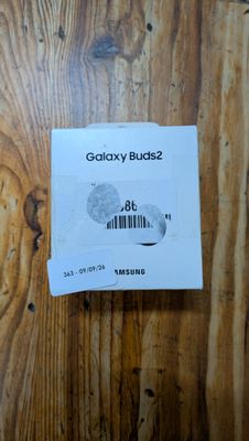 une photo de Samsung Buds 2 posés sur une table en bois