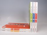 trois livres sont empilés sur une table