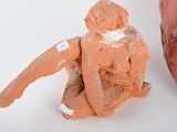 two clay sculptures of a man sitting next to each other