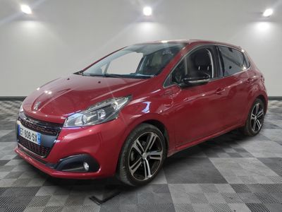 une voiture rouge est garée dans une pièce au sol en damier