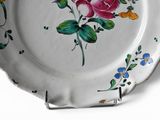 a plate with flowers painted on it on a white surface