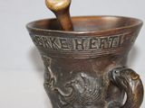 a metal cup with a wooden spoon in it
