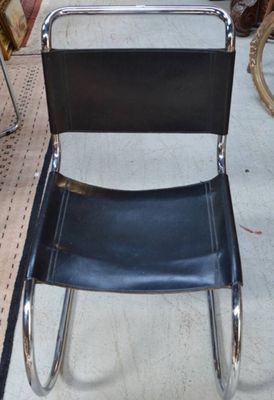 une chaise noire qui se trouve au milieu d'une pièce