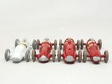 four toy cars that are lined up on a white surface