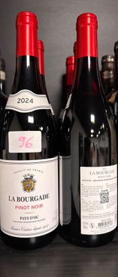 plusieurs bouteilles de vin rouge sont alignées sur une étagère