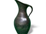 a green vase that is sitting on a white surface