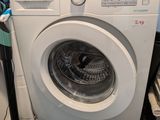 une machine à laver qui se trouve dans le coin d'une pièce