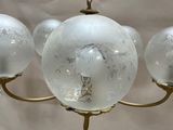 a chandelier with five glass globes hanging from the ceiling