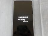 a picture of a black samsung phone on a white surface