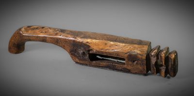 an old wooden pipe cutter on a gray surface