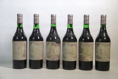 six bouteilles de vin sont alignées sur une table