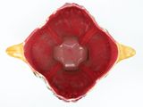 a red and yellow bowl with a flower inside of it
