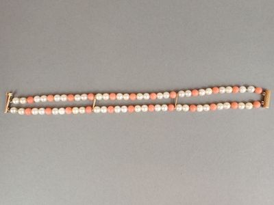 un gros plan d'un bracelet en perles posé sur une surface grise