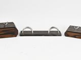 trois morceaux de bois et de métal sont posés sur une surface blanche