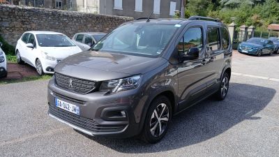 La camionnette grise est garée sur le bord de la route, sur le parking.