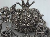 an image of a silver broochle with flowers and hearts on it