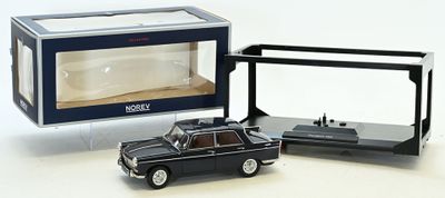 une petite voiture noire devant une boîte transparente