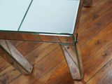 a glass table with a mirror top on a wooden floor