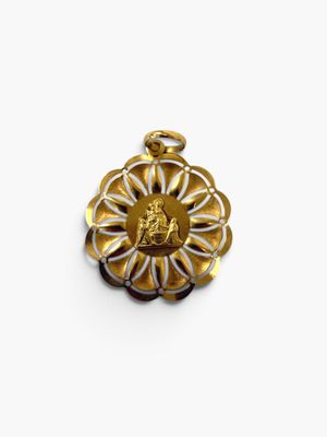 un gros plan d'un pendentif en forme de fleur dorée et blanche sur fond blanc