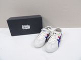 pair of white sneakers with blue and red stripes and a black box