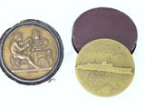two gold medals sitting next to each other on top of a white surface