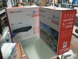 Deux cartons contenant des téléviseurs sont empilés sur une table dans un magasin.