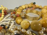 a lot of beads and bracelets that are on a table