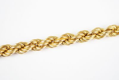 a close up of a gold chain on a white background