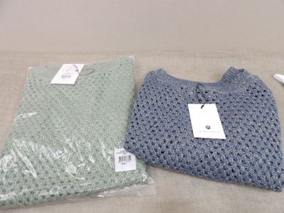 deux sacs de pulls posés sur une table, avec une étiquette de prix