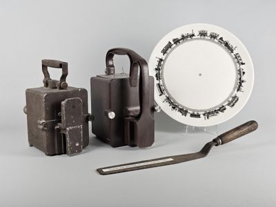 une assiette blanche ornée d'un motif en noir et blanc, à côté d'un ensemble d'outils et d'une assiette blanche ornée d'un motif en noir et blanc
