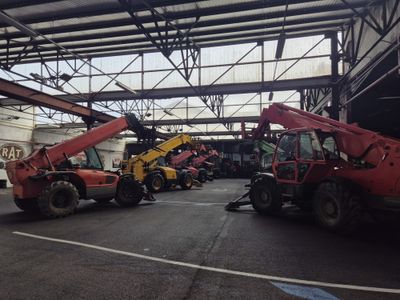 a red crane that is sitting in the middle of a parking lot